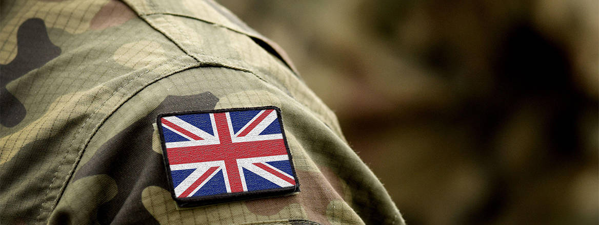 A badge of a UK flag on the shoulder of a person wearing UK military uniform