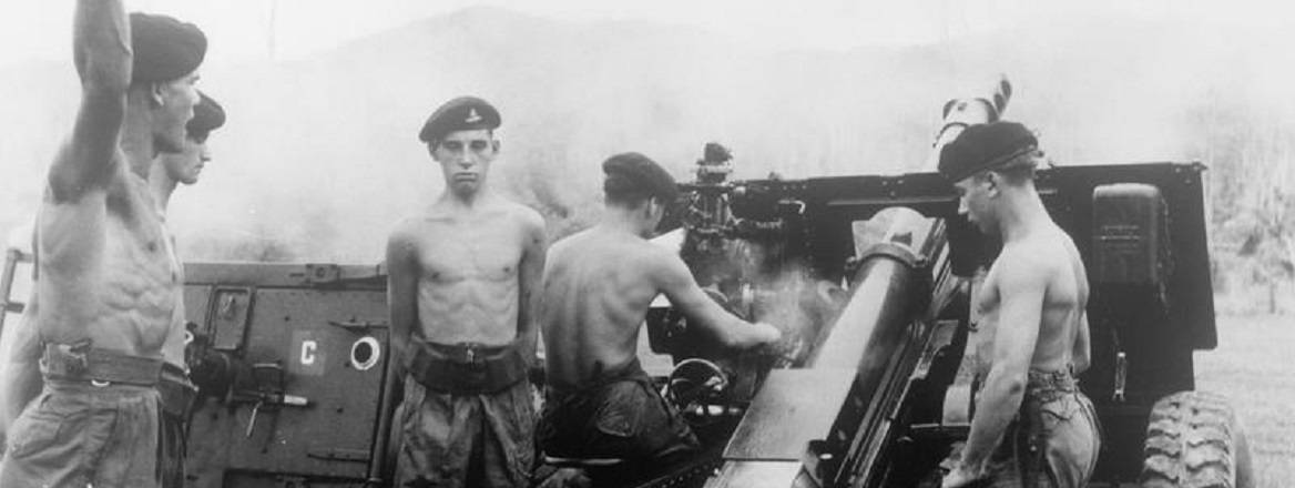 Historical black and white photograph of British personnel firing artillery in Malaya. Courtesy of Imperial War Museums