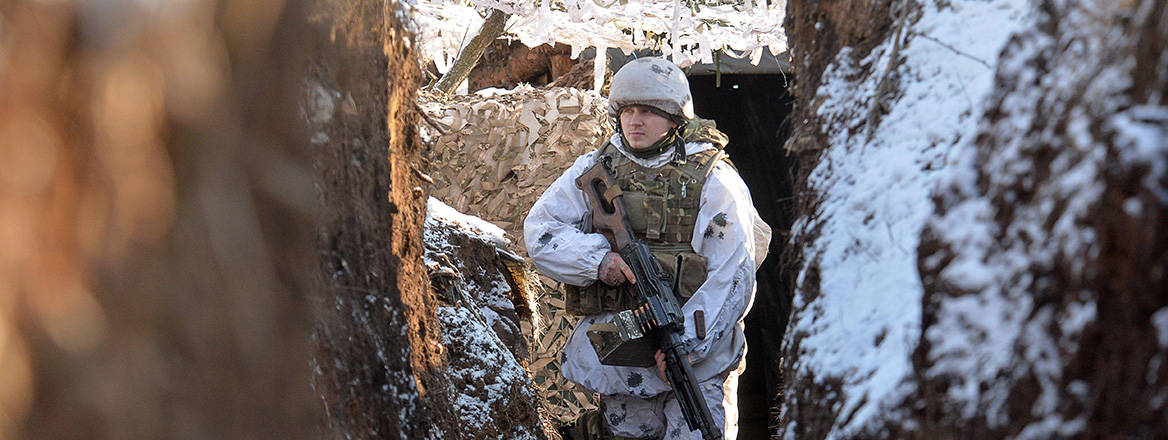 A Ukrainian soldier in a trench near the line of separation from Russian-backed rebels in the Donetsk region, 5 February 2022. Courtesy of Reuters / Alamy Stock Photo