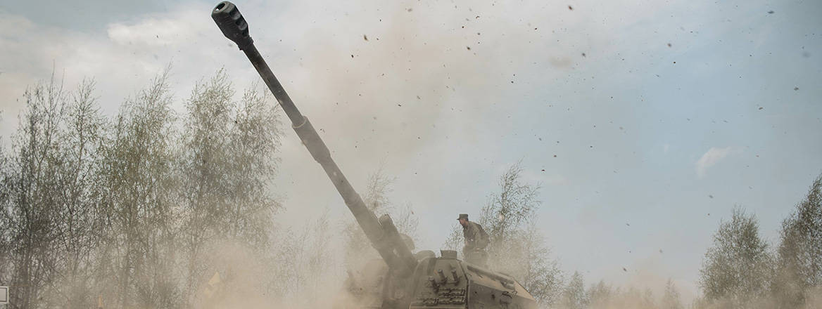 A Russian self-propelled howitzer in a cloud of dust raised by the platform's artillery fire.