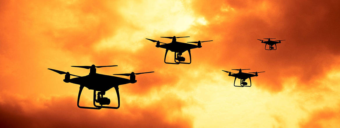 Stock image, the silhouette of drones flying in formation.