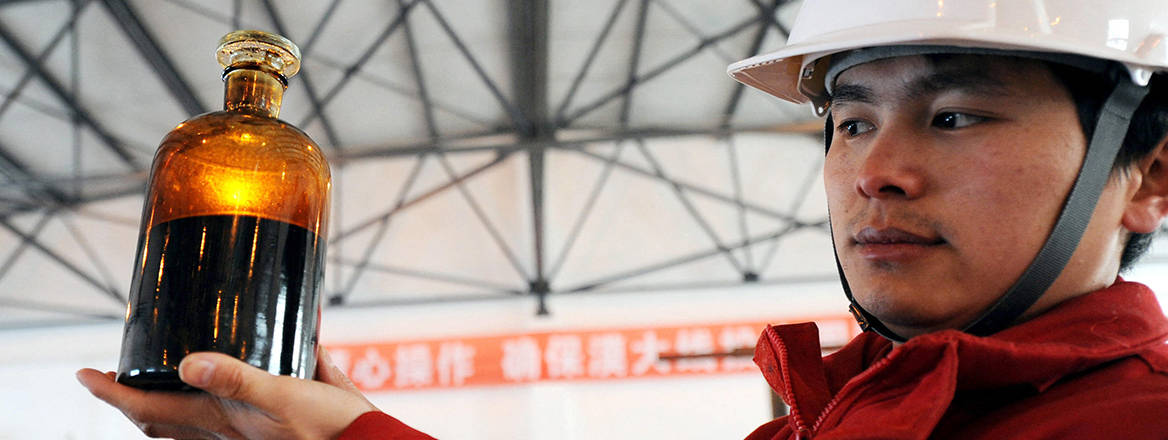  A worker from the China National Petroleum Corporation shows a bottle of crude oil sampled from the oil pipe at the terminal of the China-Russia oil pipeline in Daqing city.