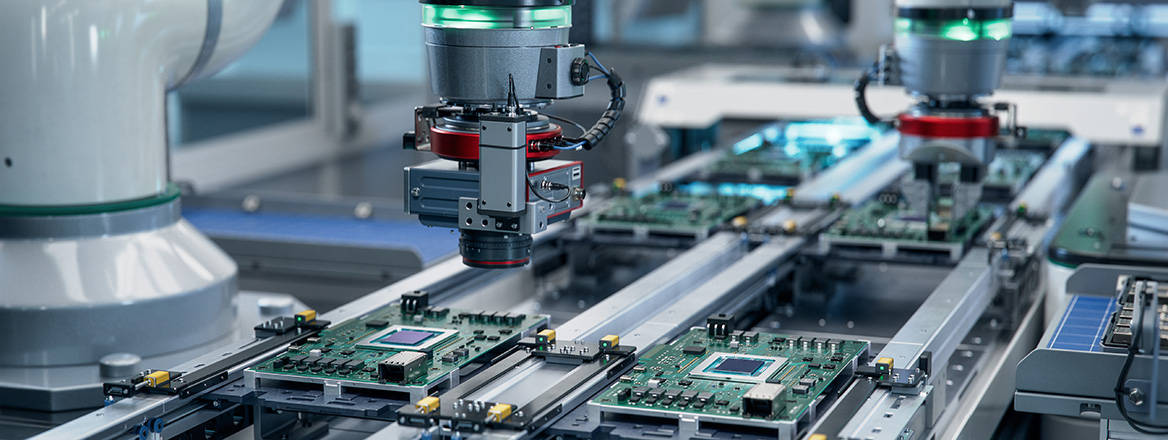 A fully automated PCB assembly line equipped with high precision robot arms at an electronics factory.