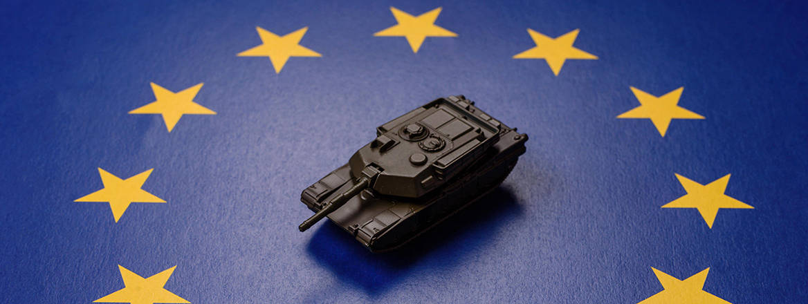 A concept image of a battle tank laying in the centre of the EU flag. 