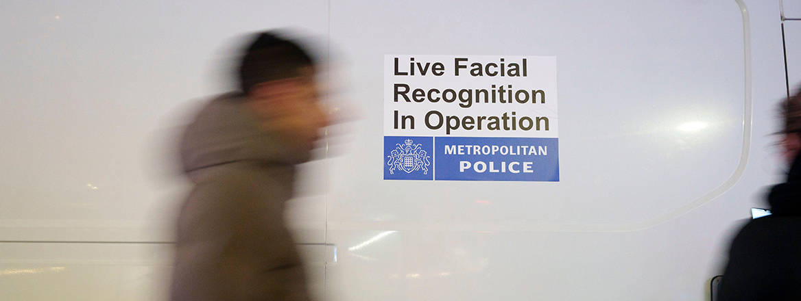 Shoppers walk past a Met police van that's using Artificial Intelligence (AI) Facial Recognition (FI) technology to spot persons of interest, and pre-empt criminal activity, at Tottenham Court Road, on 1 December 2025, in London, England.