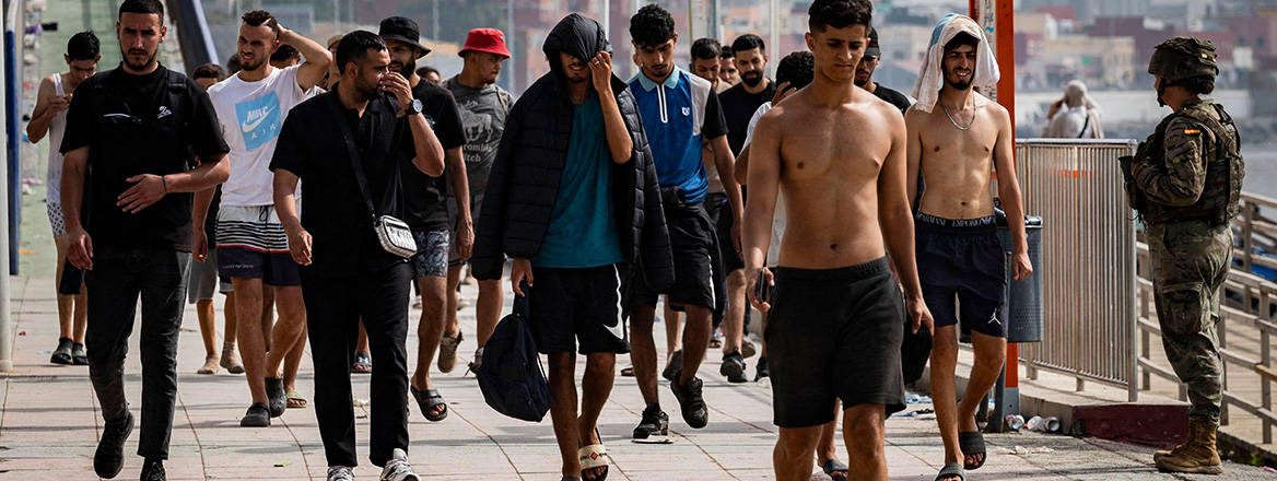 Migrants cross back from Ceuta into Morocco through the Tarajal border crossing during the early morning hours. 