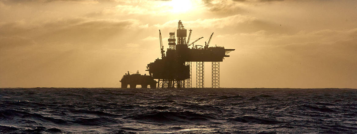 Silhouette of a drilling rig in the North Sea at sunset. 