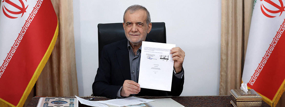 Iranian President Masoud Pezeshkian displays a memorandum of understanding after signing it in Tehran, after the document was signed by US President Donald Trump.