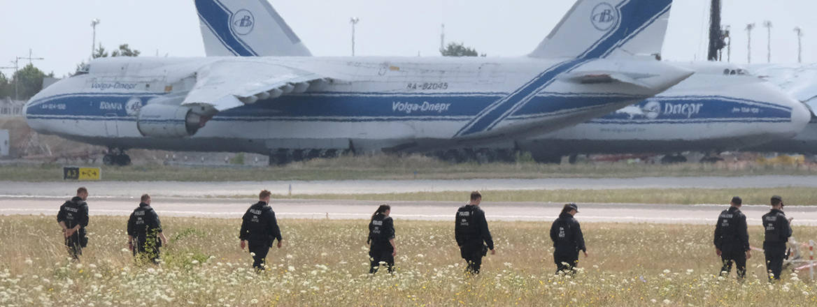 Police officers are walking across a field on the grounds of Leipzig Airport, in Schkeuditz, Germany, Friday, Aug. 7, 2026, searching for a drone that may be connected to a suspected attack.