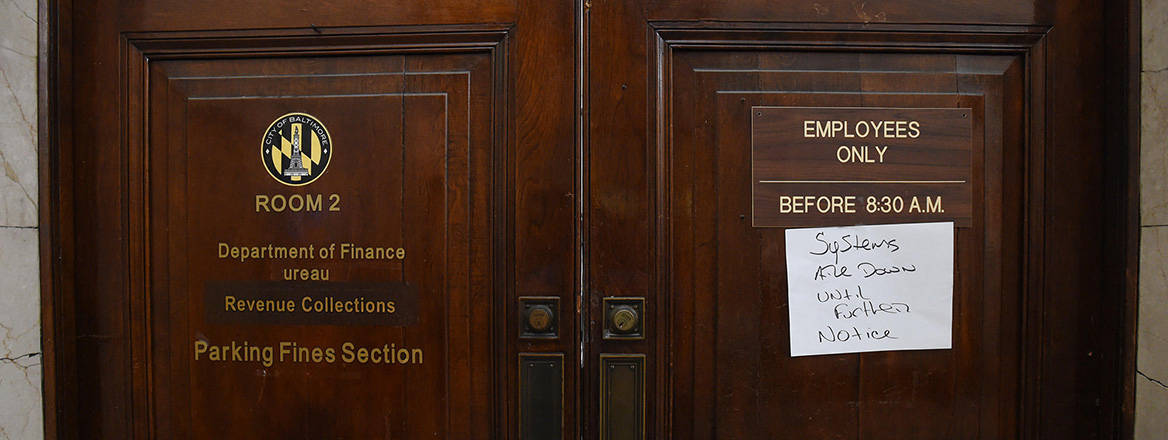 Doors of the Baltimore Department of Finance, Bureau of Revenue Collections Parking Fines Section, with a hand written note reading 'Systems are down until further notice'. 08th May, 2019. 
