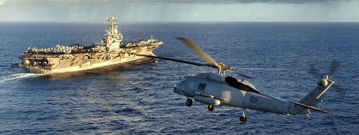 US Navy (USN) SH-60F Seahawk helicopter, Helicopter Anti-Submarine Squadron 4 (HS-4), Black Knights, Naval Air Station North Island (NASNI) flies as channel guard for the USN Nimitz Class Aircraft Carrier USS JOHN C. STENNIS (CVN 74). 