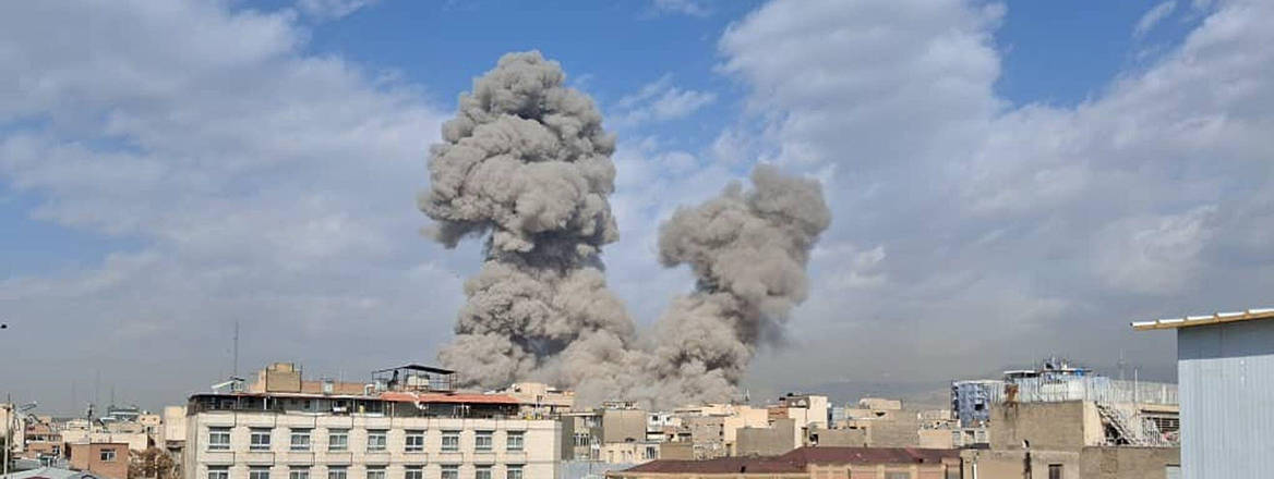 People watch as smoke rises on the skyline after an explosion in Tehran, Iran, 28 February, 2026.