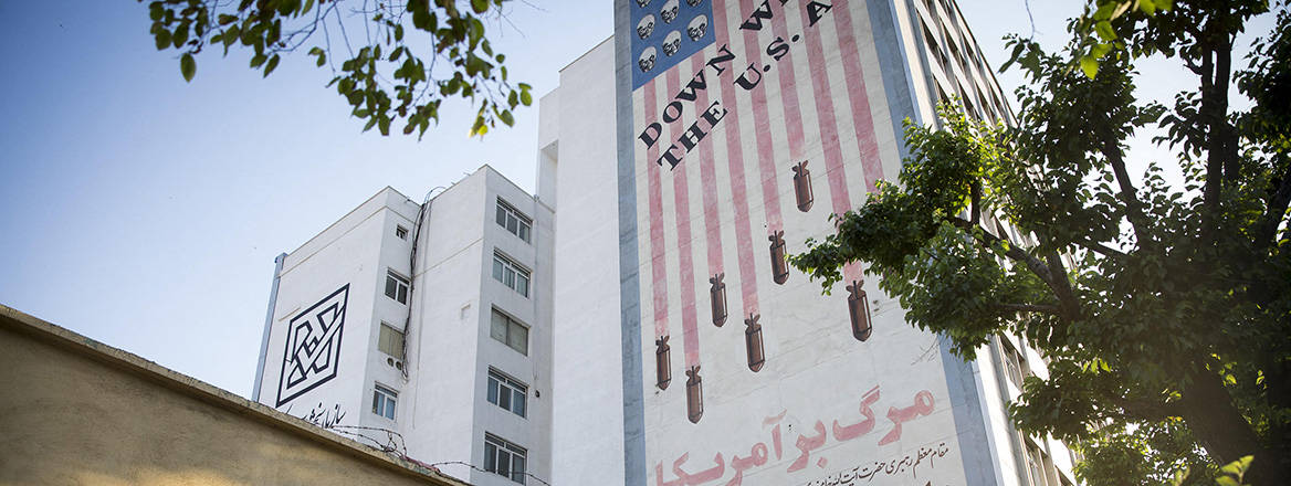 Iranian pedestrians walk past an anti-American mural in downtown Tehran, Iran.