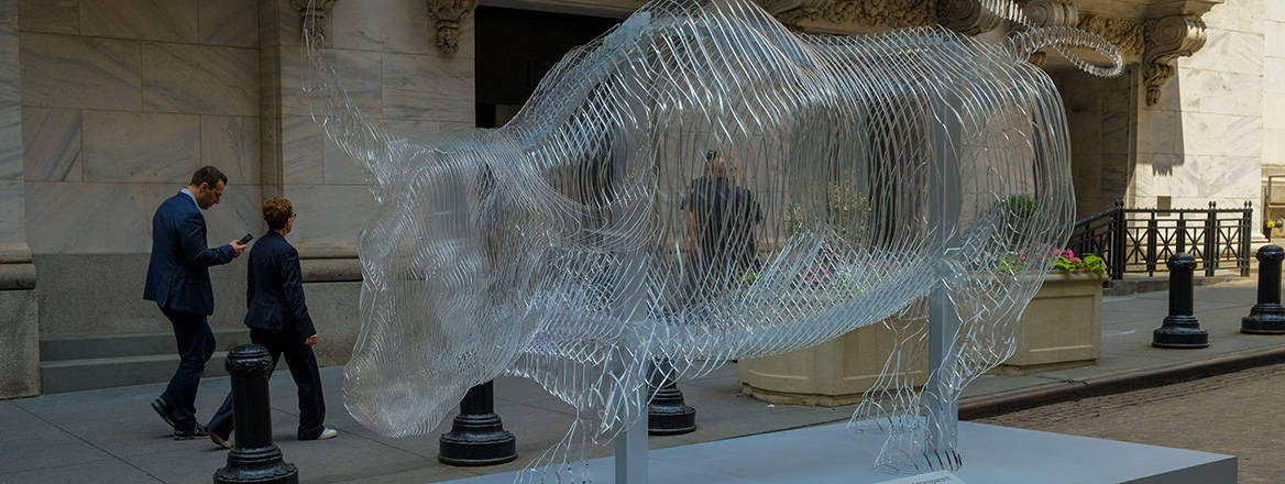 A transparent bull sculpture in front of the New York Stock Exchange.