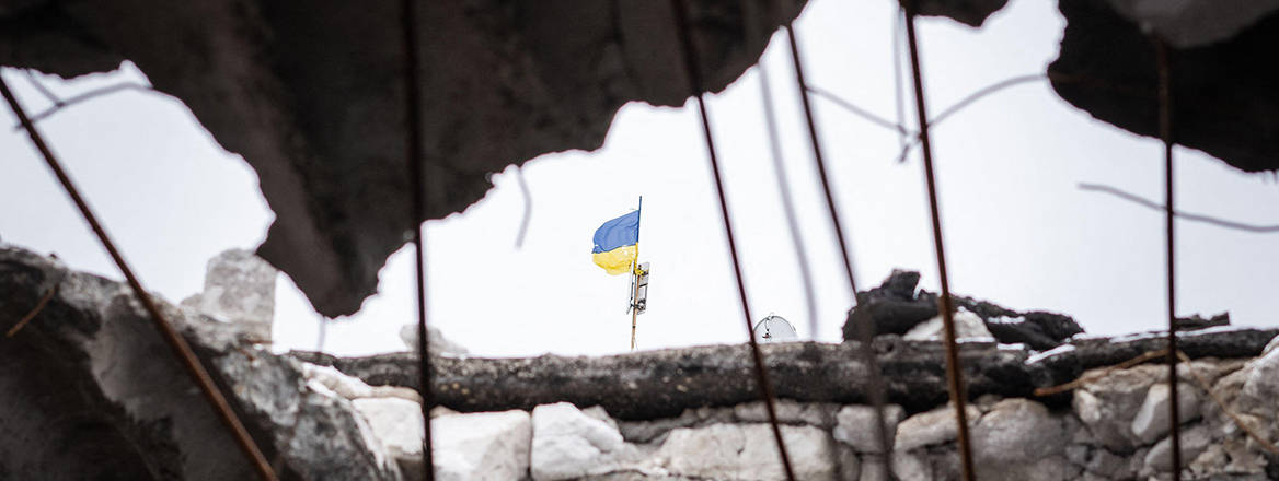 Ukrainian flag seen from the roof breach of a destroyed school, once occupied as Russian headquarters in Mirolybivka, Kherson
