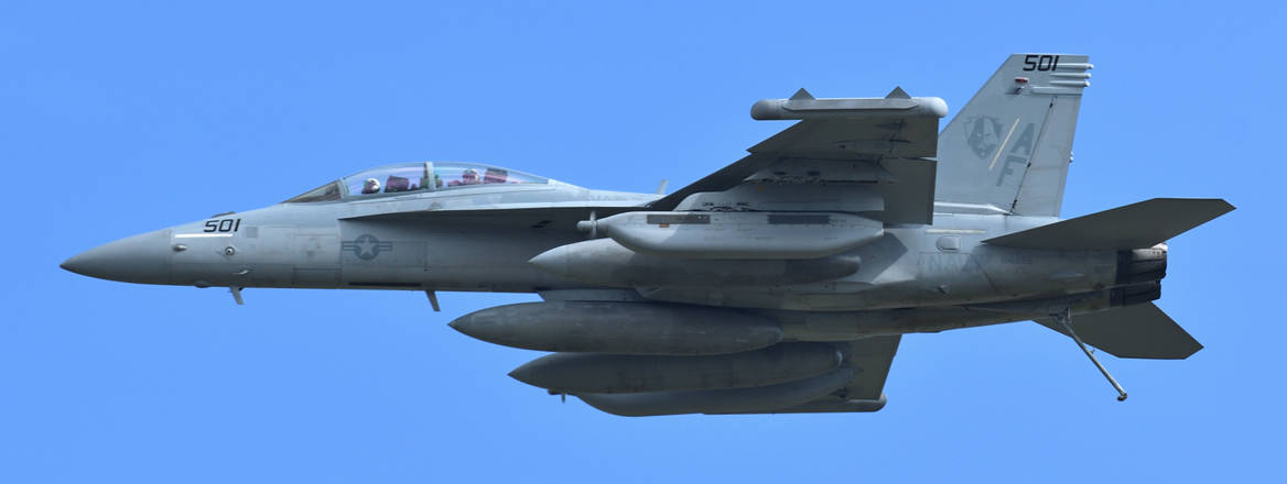 US Navy Boeing EA-18G Growler electronic warfare aircraft flying against blue sky