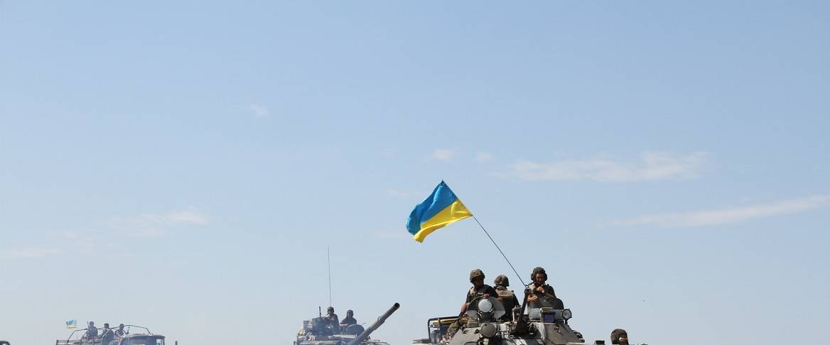 soldiers in a tank with Ukrainian Flag