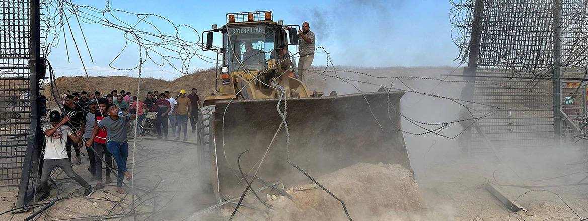 Breaking through: Palestinians cross the border fence with Israel from the southern Gaza Strip on 7 October 2023