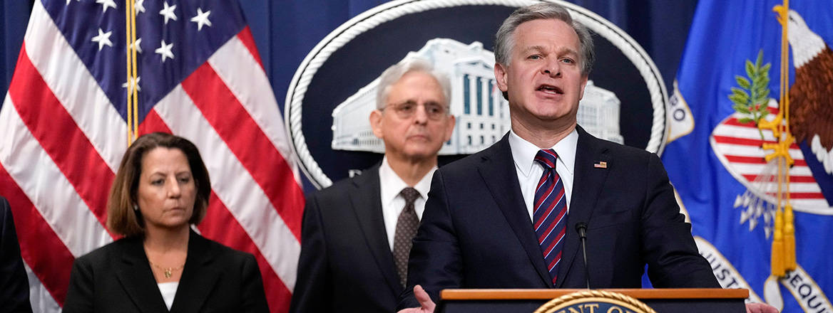 FBI Director Christopher Wray speaks at the Department of Justice on the capture of three men plotting to kill an Iranian–American activist, January 2023. Courtesy of Associated Press/Alamy.