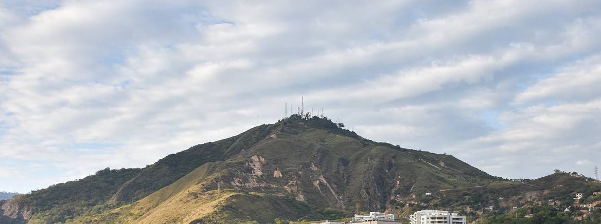 high rise building near a green mountain