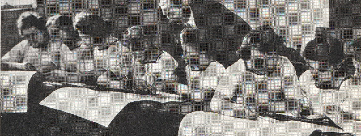 Several young women in uniform sit at desks, focused on maps laid out before them, while a man in a suit looks on. Courtesy of Wrens in Camera (London: Hollis and Carter, 1945).