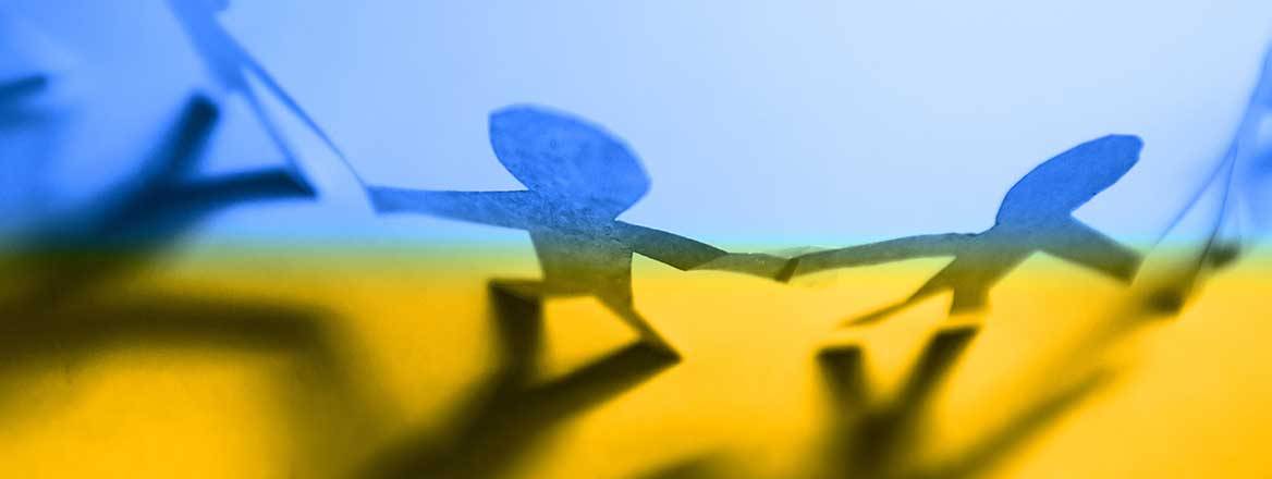 Figures holding hands on Ukrainian flag to illustrate public-private partnerships in Ukraine