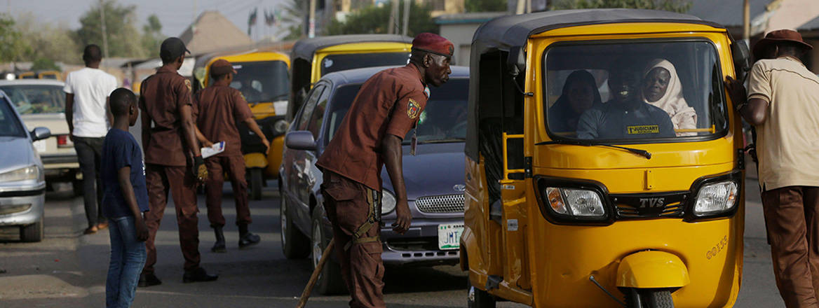 Filling the vacuum: vigilantes search vehicles on a street in Yola, Nigeria