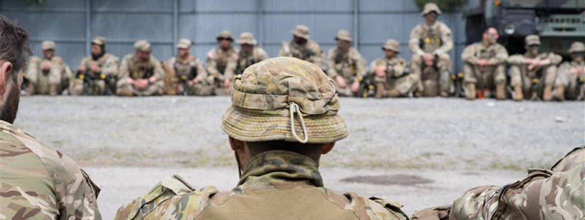 Soldiers of 19th Light Brigade during a de-brief include Service exchange personnel from the Australian Army (centre front) and, in the background, from the US National Guard. Exercise RHINO HEART