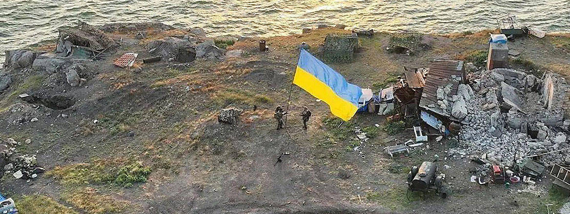 Ukrainian service people planting a national flag on Snake Island in the Black Sea, 7 July 2022. Courtesy of Zuma Press / Alamy