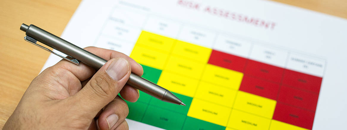 A "Risk assessment" safety matrix color level document which is placed on desk.