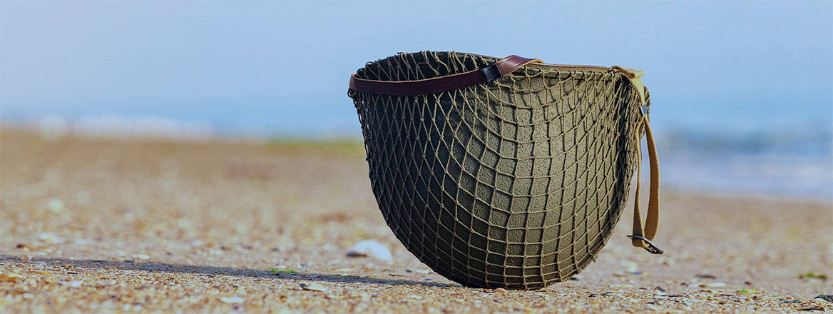 A Second World War American helmet on a beach of the Normandy landings. Courtesy of Andia / Alamy Stock Photo