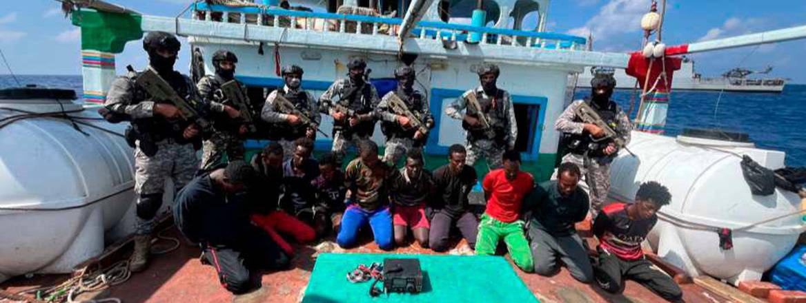 Caught red-handed: Indian Navy commandos stand behind pirates captured off the east coast of Somalia on 29 January