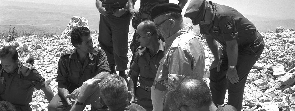 Israeli Prime Minister Levi Eshkol (centre) with Defence Minister Moshe Dayan (sitting, centre) and senior staff officers visiting the northern border area on the Golan Heights. To the left of Dayan, sitting, is David Elazar, who leads the Northern Command, 10 June 1967. Courtesy of Eli Nissan/Israeli Government Press Office/Wikimedia Commons