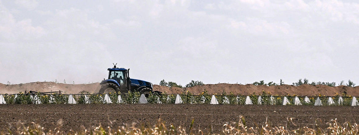 A tractor with an electronic warfare device installed on its roof against Russian fi rst-person-view drones moves along the line of pyramidal anti-tank obstacles (dragon’s teeth) in a fi eld near Orikhiv, a city in the Polohy district, Zaporizhzhia region, Ukraine. Courtesy of Dmytro Smolienko / Ukrinform / Alamy