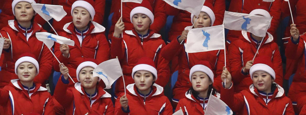 North Korean cheerleaders wave the Korean Unification flag