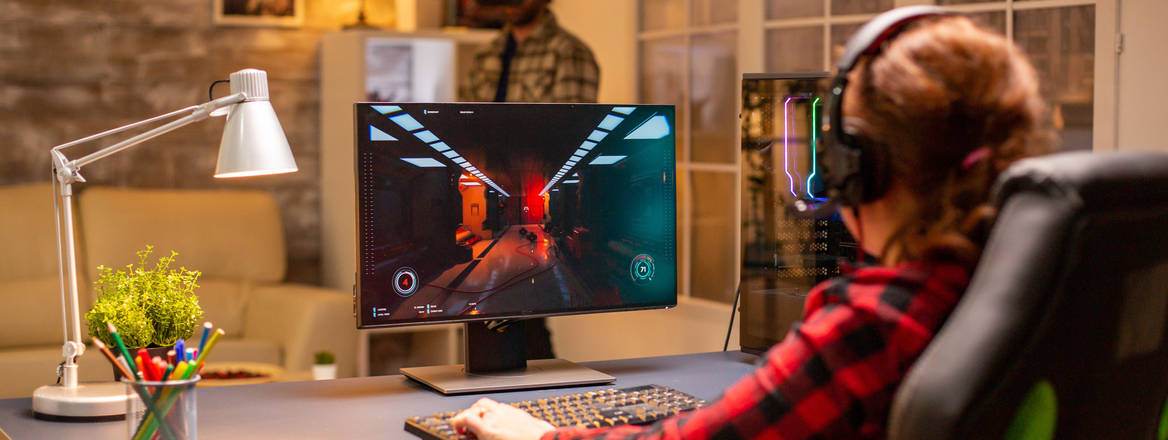 young female playing on a computer game in warm yellow tone room