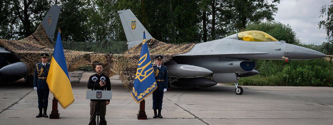 Established wing: Volodymyr Zelensky talks on the occasion of the Air Forces Day standing against the background of Ukraine's Air Force's F-16 fighter jets, 4 August 2024. Image: Associated Press/Alamy