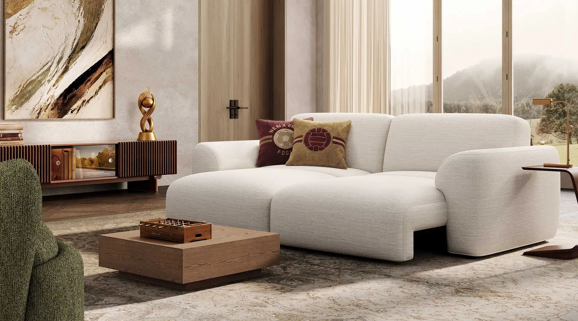 White two-seater sofa with rounded arms and deep cushions in a bright modern living room with large windows and a wooden coffee table.