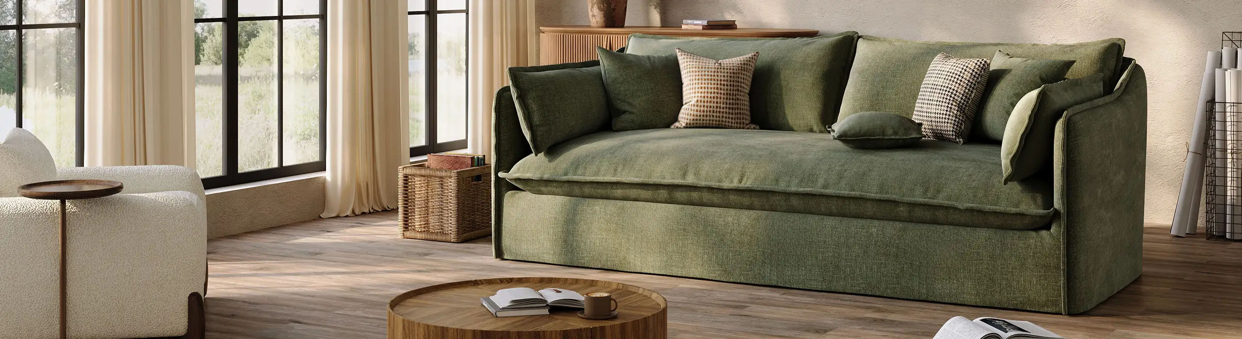 Plush green sofa with deep cushioning and multiple throw pillows in a bright modern living room with large windows.