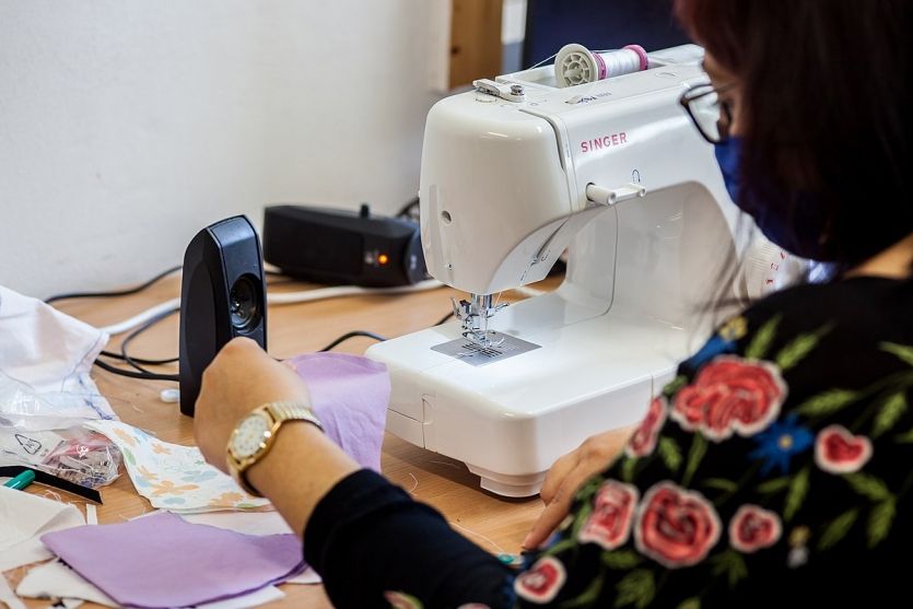 dobrovolníci šijí roušky