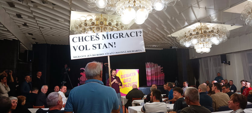 Účastník debaty s transparentem