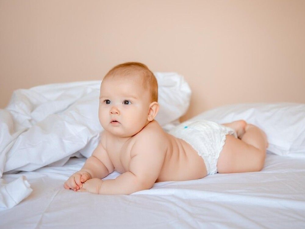 baby-boy-diaper-is-lying-white-sheet-covered-with-blanket-bedroom-bed_106368-5865.jpg