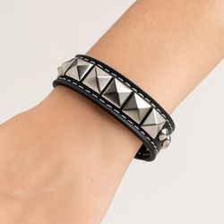 Svart armbånd med runde og pyramideformede ørestikker
