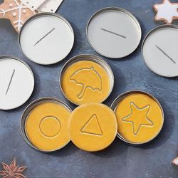 24-osainen kalmari-keksimuottipelisetti, peltirasia ja neula