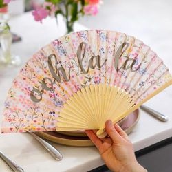 Talking Tables Opvouwbare Opvouwbare Handheld Hand Fan ditsy bloemenprint en leest 'Ooh la' in kalligrafie tekst. Lichtgewicht bamboe.| Verpakt in organza zakje |Ontworpen in UK