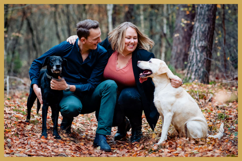 Twee gelukkig mensen met wee gelukkige labradors.