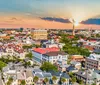 A picturesque street view showcasing historic architecture with a steeple towering in the background under a sky dotted with fluffy clouds