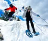 A group of hikers ascends a snowy slope under a bright sun