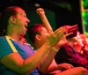 An audience member is expressing excitement and joy with a wide smile and clenched fist at an event