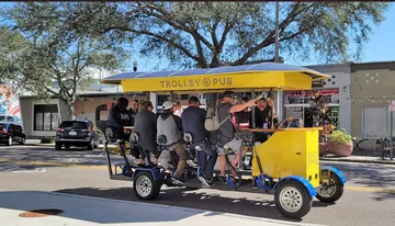 A group of people enjoys a ride on a pedal-powered 